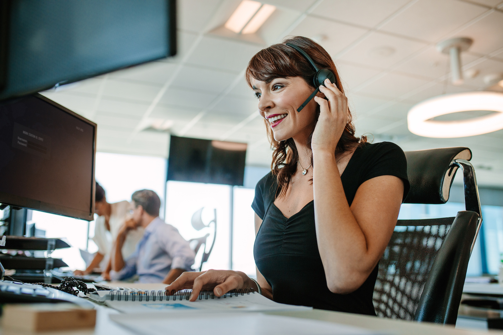 Call center business woman talking on headset. Caucasian female in customer service position talking on the phone.